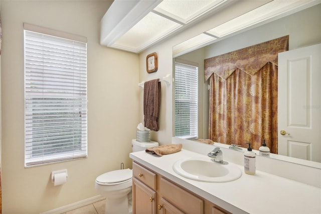 bathroom with toilet, vanity, and tile patterned floors