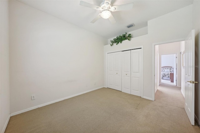 unfurnished bedroom with light carpet, a closet, and ceiling fan