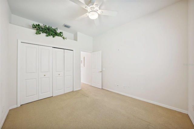 unfurnished bedroom featuring a closet, ceiling fan, and light colored carpet