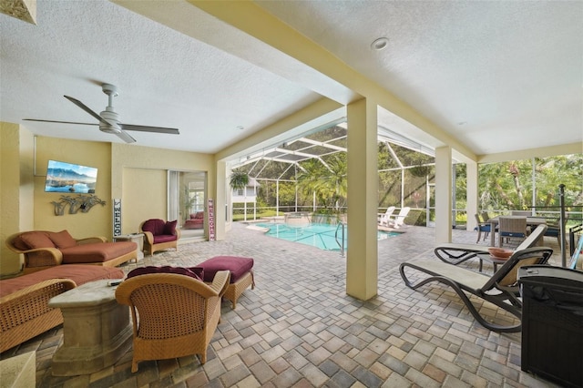 view of pool with a patio area, an outdoor living space, a lanai, and ceiling fan