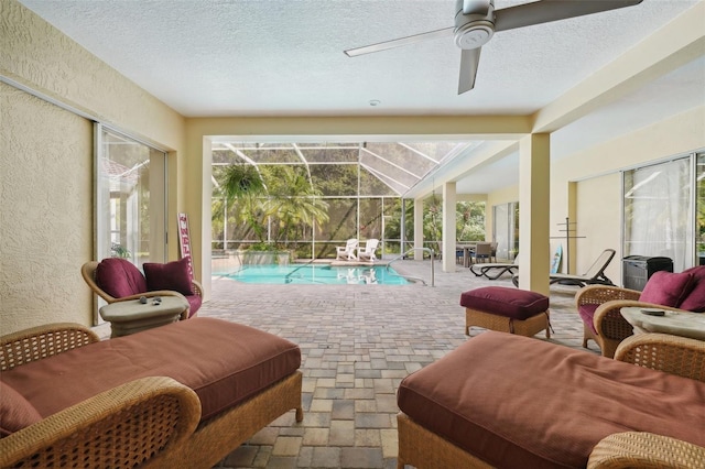 sunroom with a swimming pool and ceiling fan