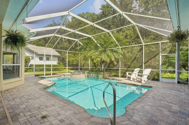 view of pool featuring a patio, an in ground hot tub, and glass enclosure