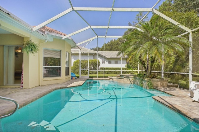 view of pool with a patio and glass enclosure