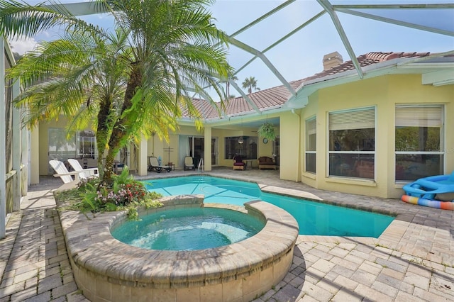 view of swimming pool with an in ground hot tub, a patio area, and a lanai