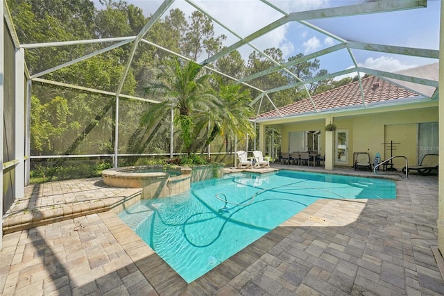 view of pool featuring an in ground hot tub, ceiling fan, glass enclosure, and a patio area