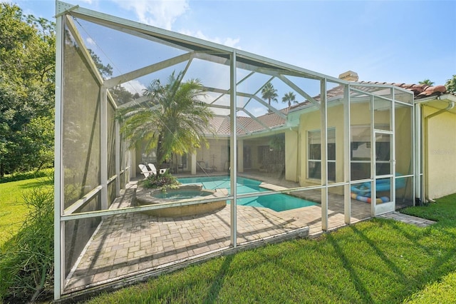 view of swimming pool with a patio area, a lanai, an in ground hot tub, and a lawn