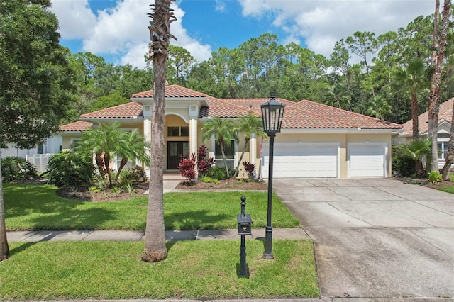 mediterranean / spanish-style home with a front yard and a garage