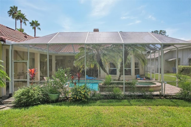 back of property with a lawn and glass enclosure