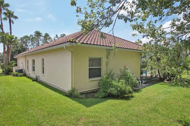 view of property exterior featuring central air condition unit and a lawn