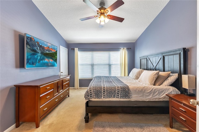 carpeted bedroom featuring vaulted ceiling, ceiling fan, and a textured ceiling