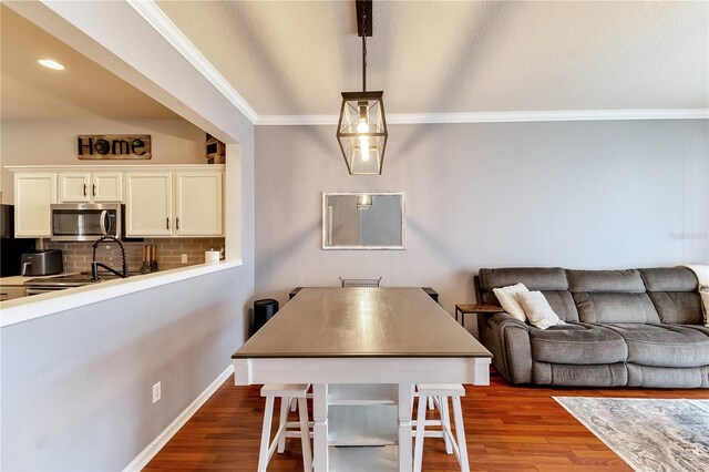 dining room featuring ornamental molding and wood-type flooring