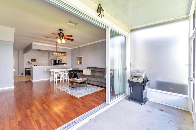 unfurnished living room featuring ornamental molding, ceiling fan, and hardwood / wood-style flooring