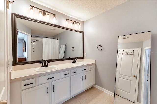 bathroom featuring walk in shower, vanity, tile patterned flooring, and a textured ceiling