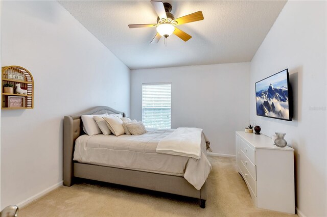 bedroom featuring ceiling fan, a textured ceiling, lofted ceiling, and light carpet