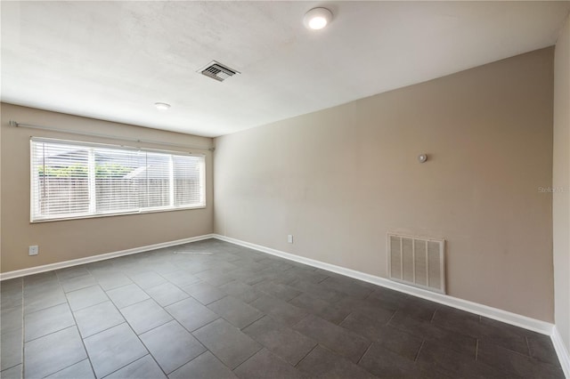 spare room featuring visible vents and baseboards