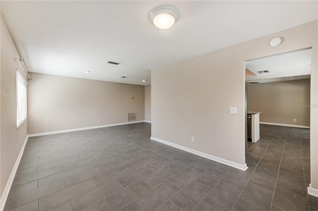 spare room with baseboards and visible vents