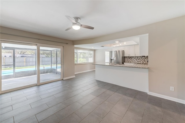 interior space with ceiling fan and baseboards