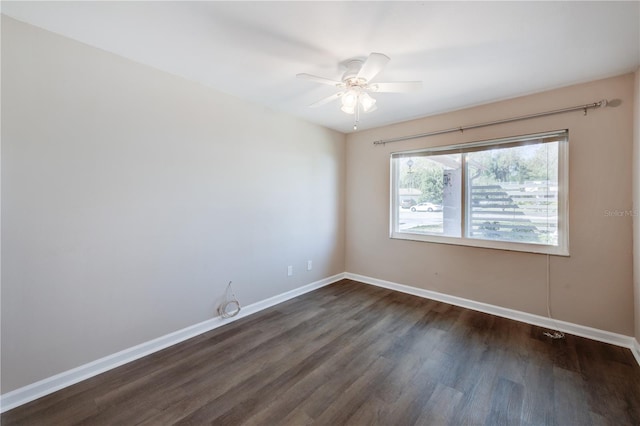 unfurnished room with a ceiling fan, baseboards, and dark wood-style flooring