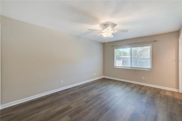 empty room with a ceiling fan, baseboards, and dark wood-type flooring