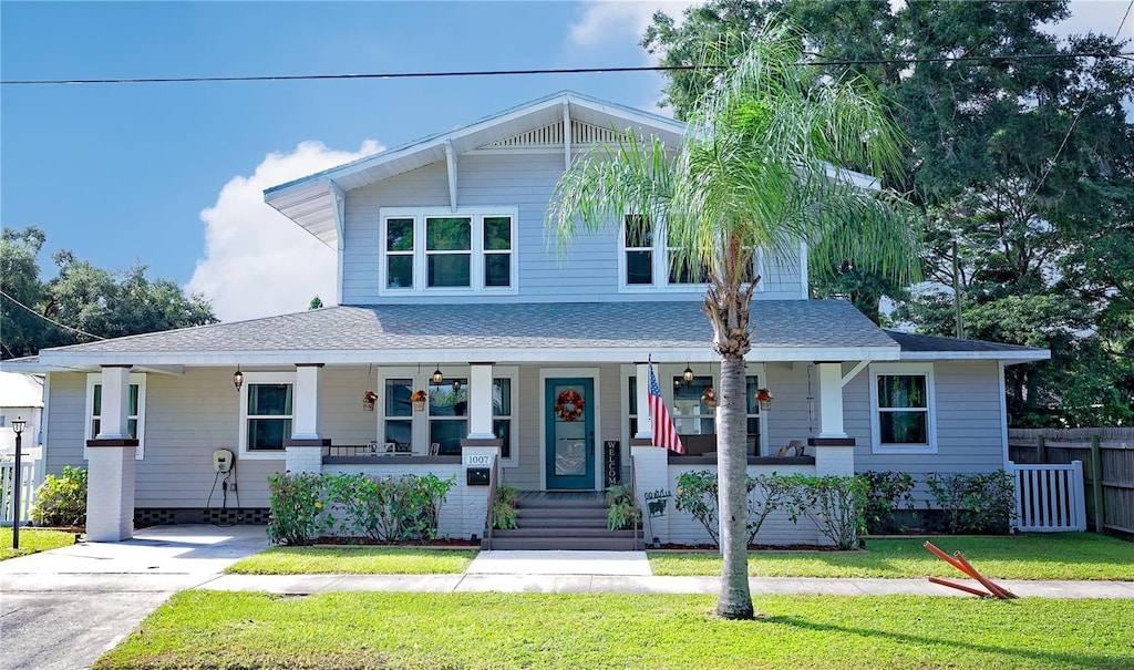 view of front of home featuring covered porch and a front yard