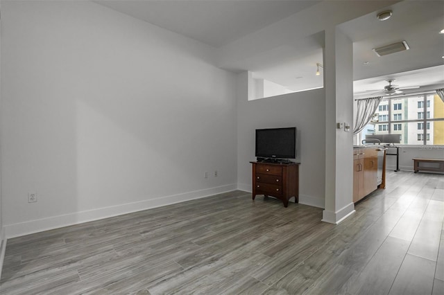 unfurnished living room featuring ceiling fan and hardwood / wood-style flooring