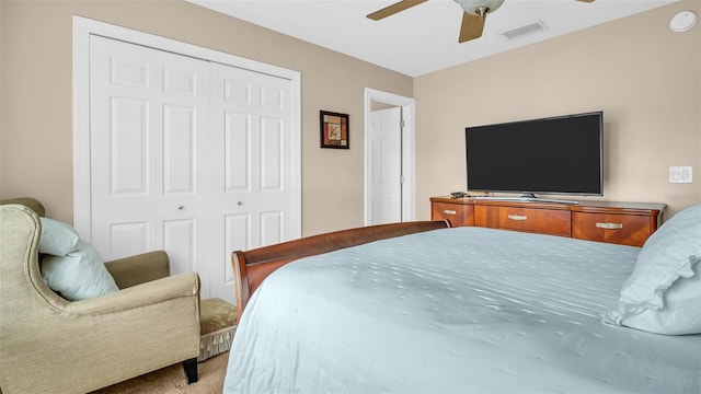 bedroom with ceiling fan, carpet floors, and a closet