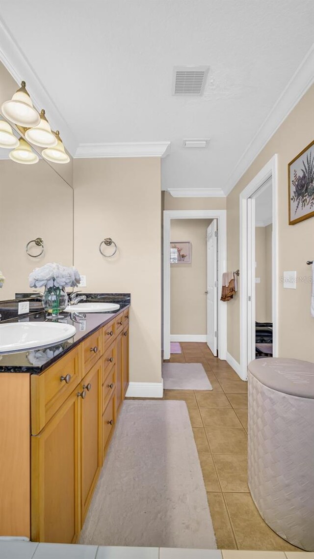 bathroom with crown molding, tile patterned flooring, and vanity