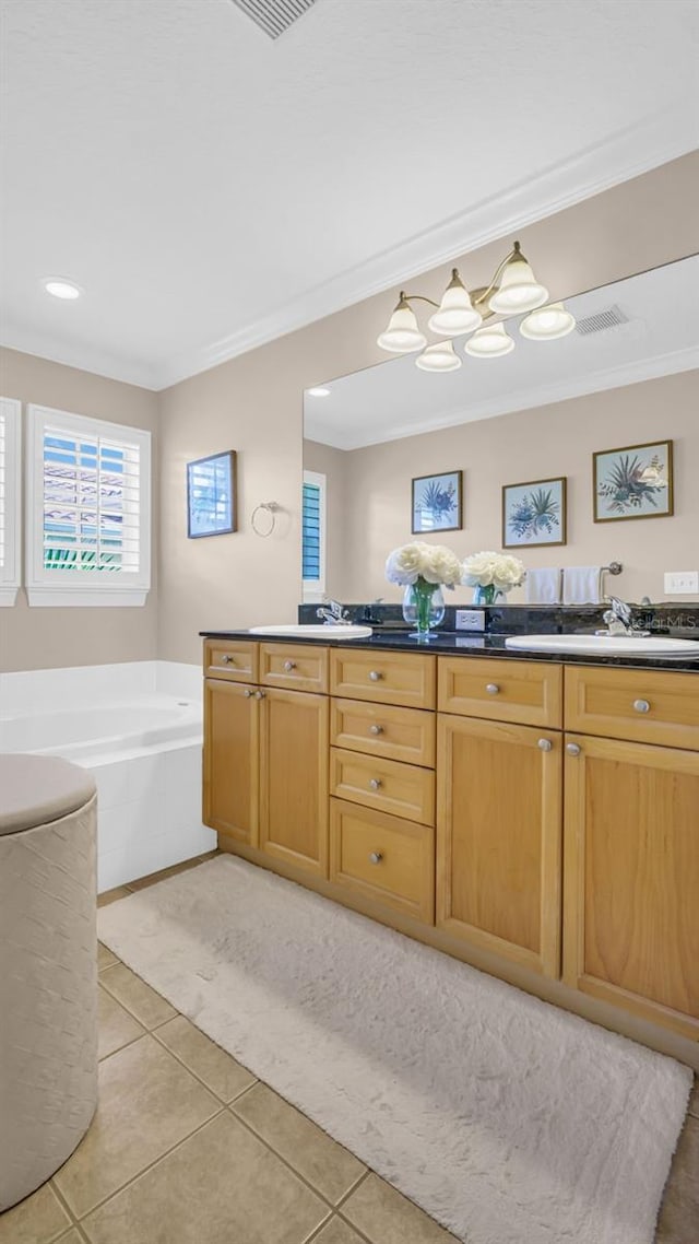 bathroom with a tub to relax in, crown molding, tile patterned flooring, and vanity