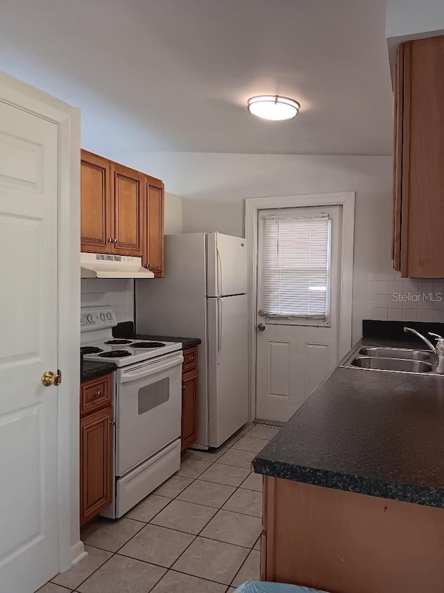 kitchen with decorative backsplash, white appliances, vaulted ceiling, and sink