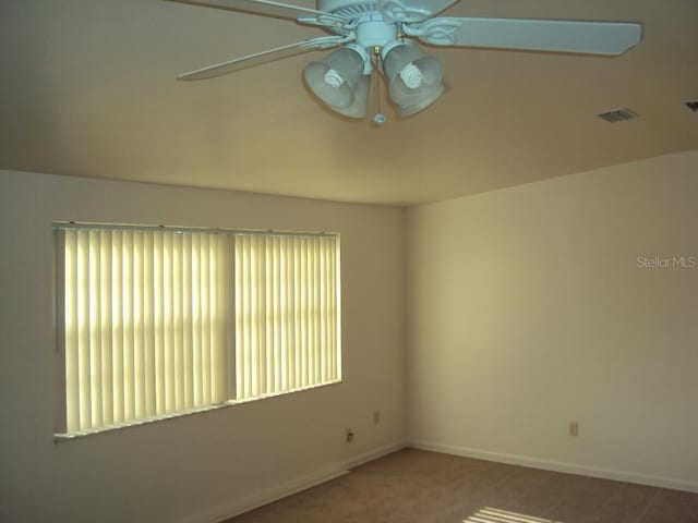 carpeted spare room with plenty of natural light and ceiling fan