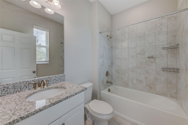 full bathroom featuring toilet, tiled shower / bath, and vanity