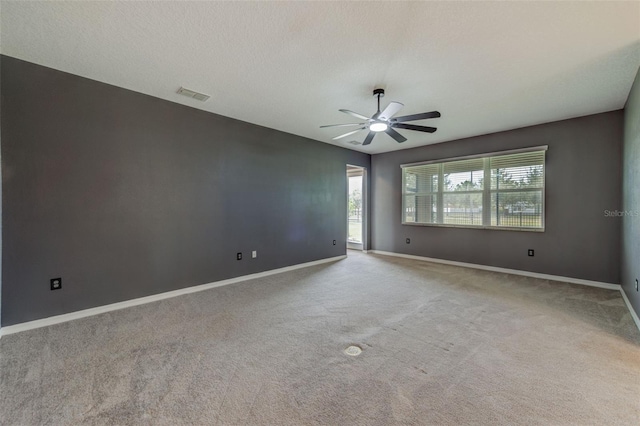 unfurnished room featuring ceiling fan, a textured ceiling, and light carpet