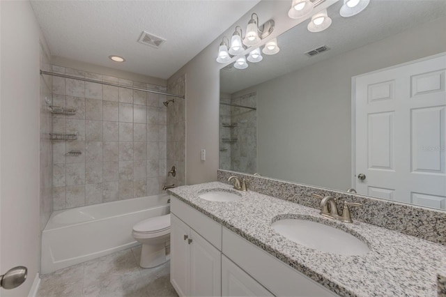 full bathroom with toilet, a textured ceiling, tiled shower / bath combo, tile patterned flooring, and vanity