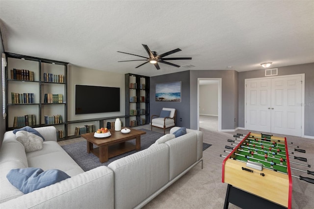 carpeted living room with ceiling fan and a textured ceiling