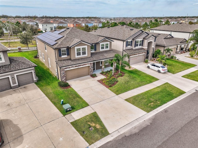 view of front of house featuring a garage, a front yard, and solar panels