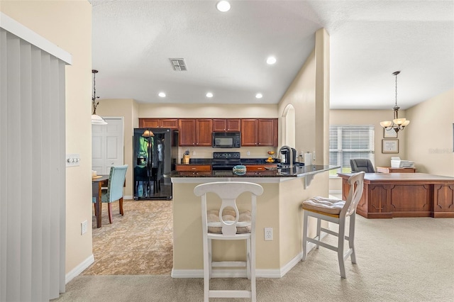 kitchen featuring kitchen peninsula, decorative light fixtures, black appliances, light carpet, and a breakfast bar area