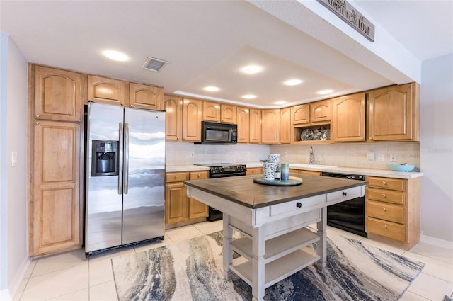 kitchen with decorative backsplash, black appliances, wood counters, and light tile patterned flooring