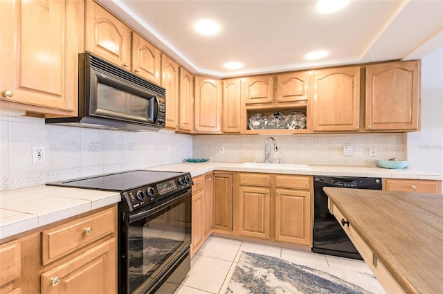 kitchen with black appliances, tasteful backsplash, light tile patterned flooring, and sink