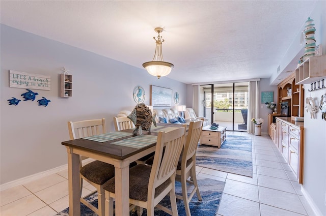 tiled dining room featuring a textured ceiling