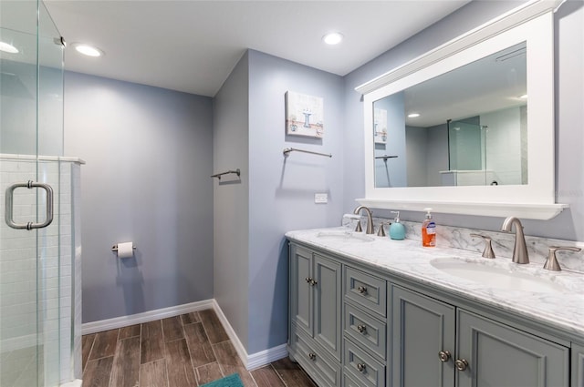 bathroom featuring wood-type flooring, a shower with door, and vanity