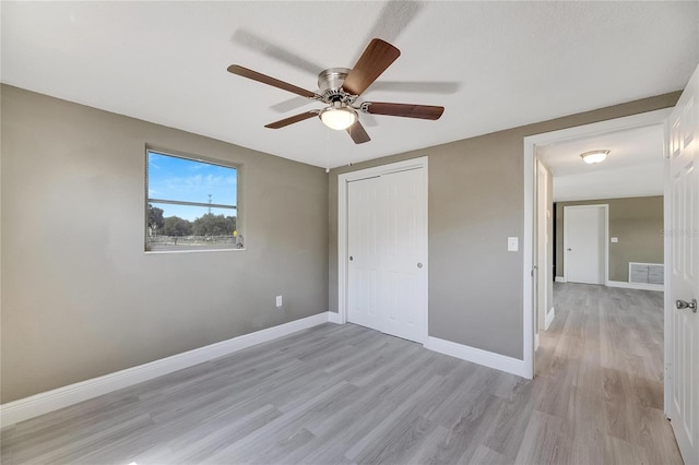 unfurnished bedroom featuring ceiling fan, light hardwood / wood-style flooring, and a closet