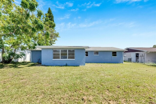 back of property featuring a lawn