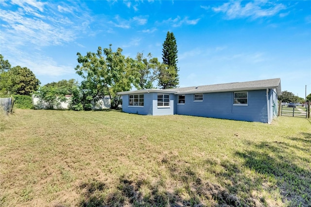 rear view of property featuring a lawn