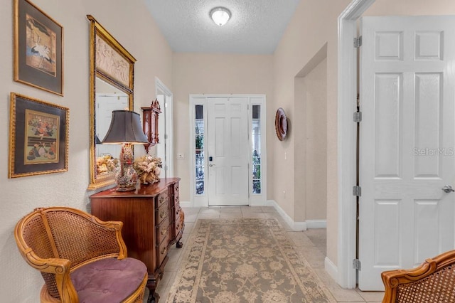 tiled entryway featuring a textured ceiling