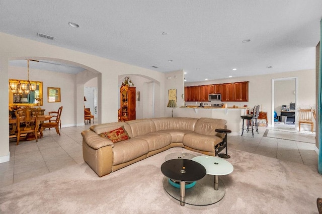 tiled living room with an inviting chandelier