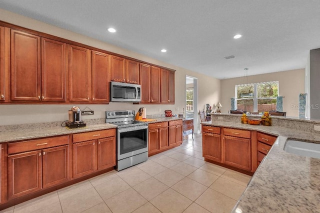 kitchen featuring pendant lighting, stainless steel appliances, light tile patterned floors, and light stone countertops