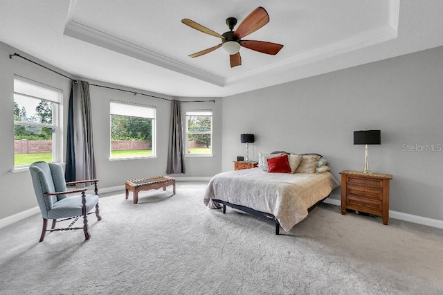 bedroom featuring a raised ceiling, carpet flooring, and ceiling fan