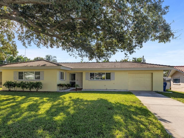 ranch-style house featuring a front lawn and a garage