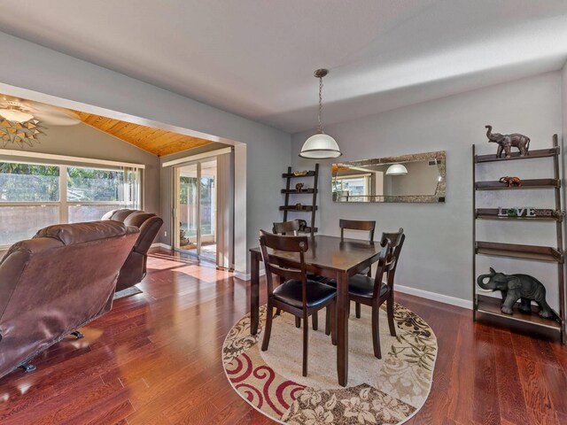 dining area featuring lofted ceiling and dark wood-type flooring