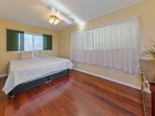 bedroom with ceiling fan and dark wood-type flooring